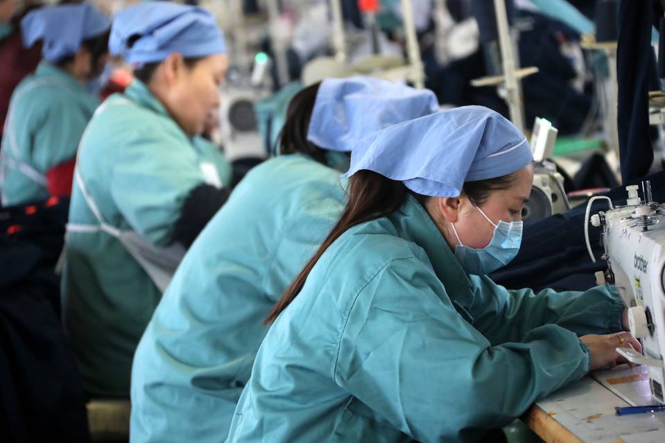 中国安徽省的一家工厂内，工人们在缝制出口至欧洲和美国的衣服。